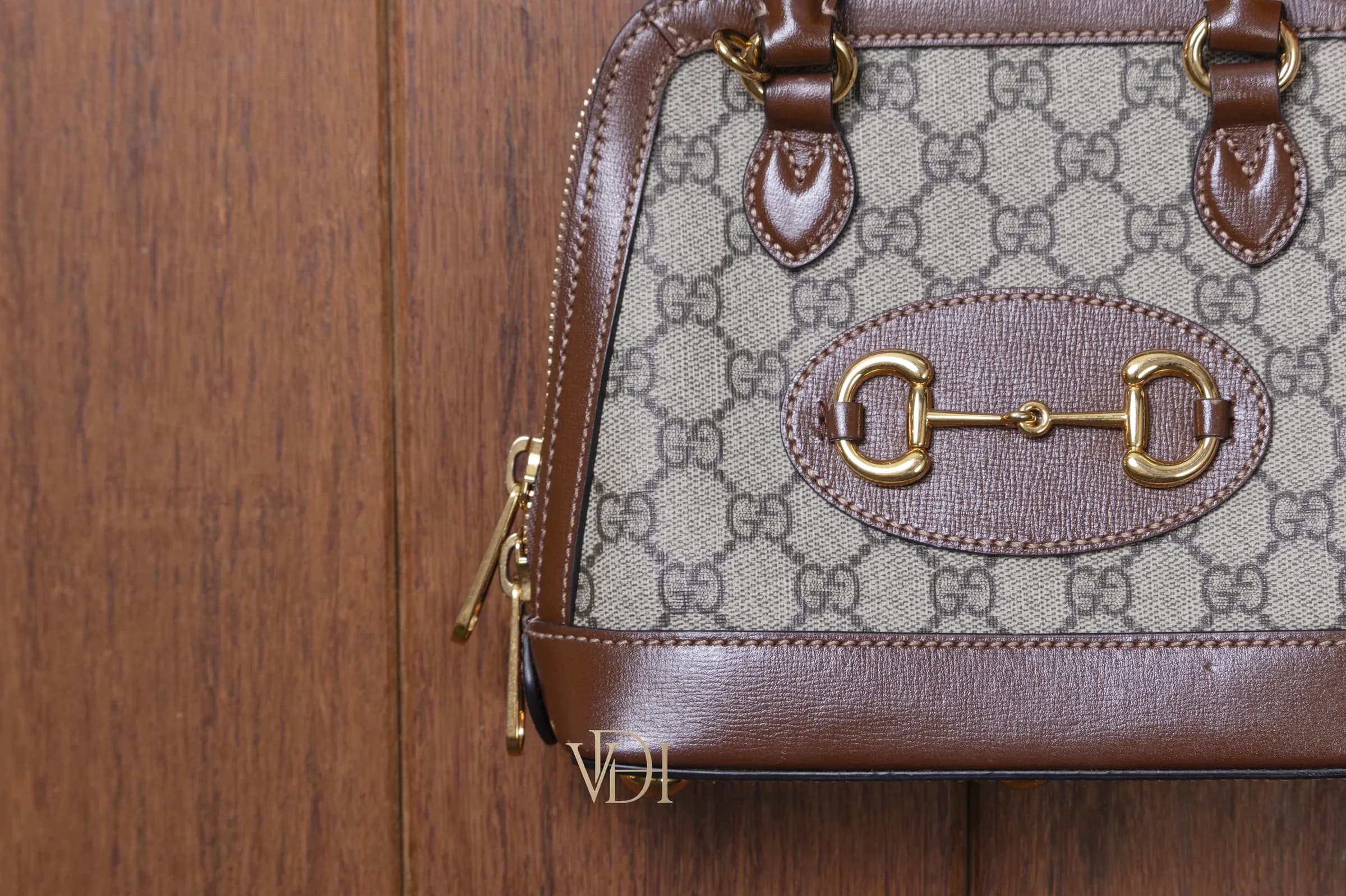 Dettaglio ravvicinato del morsetto oro Gucci 1955 Horsebit e della chiusura zip